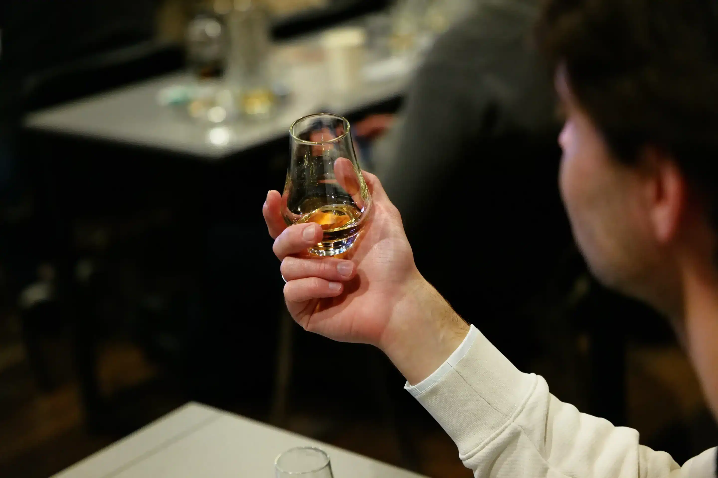 A man holding a glass of whiskey